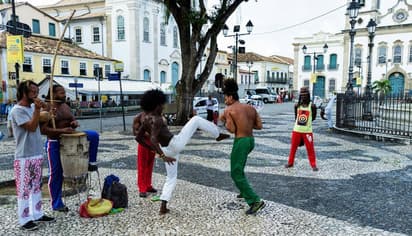 Capoeira op een historisch plein in Brazilië, waar muziek en beweging samenkomen tijdens een schooluitwisseling.