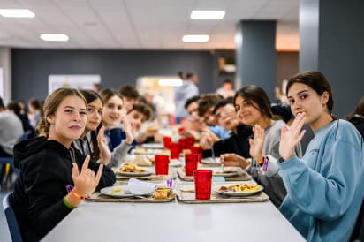 Jongeren zitten samen aan tafel in de eetzaal tijdens een taalreis naar Engeland